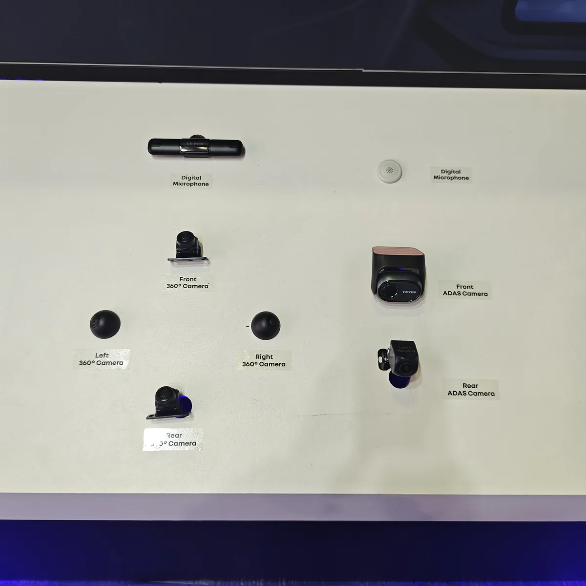 TEYES accessory wall at Automechanika Frankfurt 2026 — digital microphones, front and rear ADAS cameras, and front, rear, left and right 360-degree cameras labeled side by side