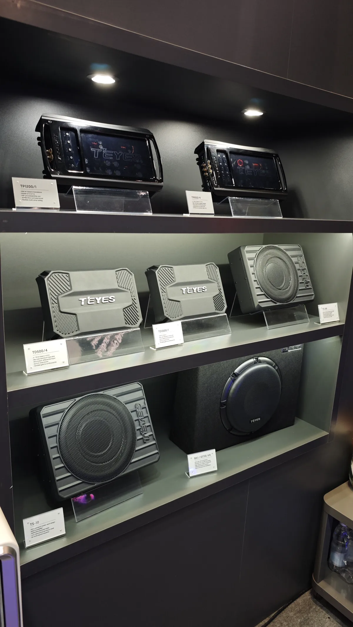 TEYES exhibition wall at Automechanika Frankfurt 2026 showing head units, amplifiers and subwoofers on three display shelves